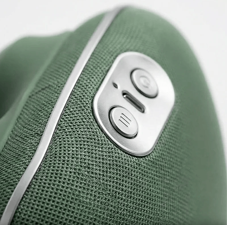 Close-up of the control buttons and charging port on the green hands-free massager