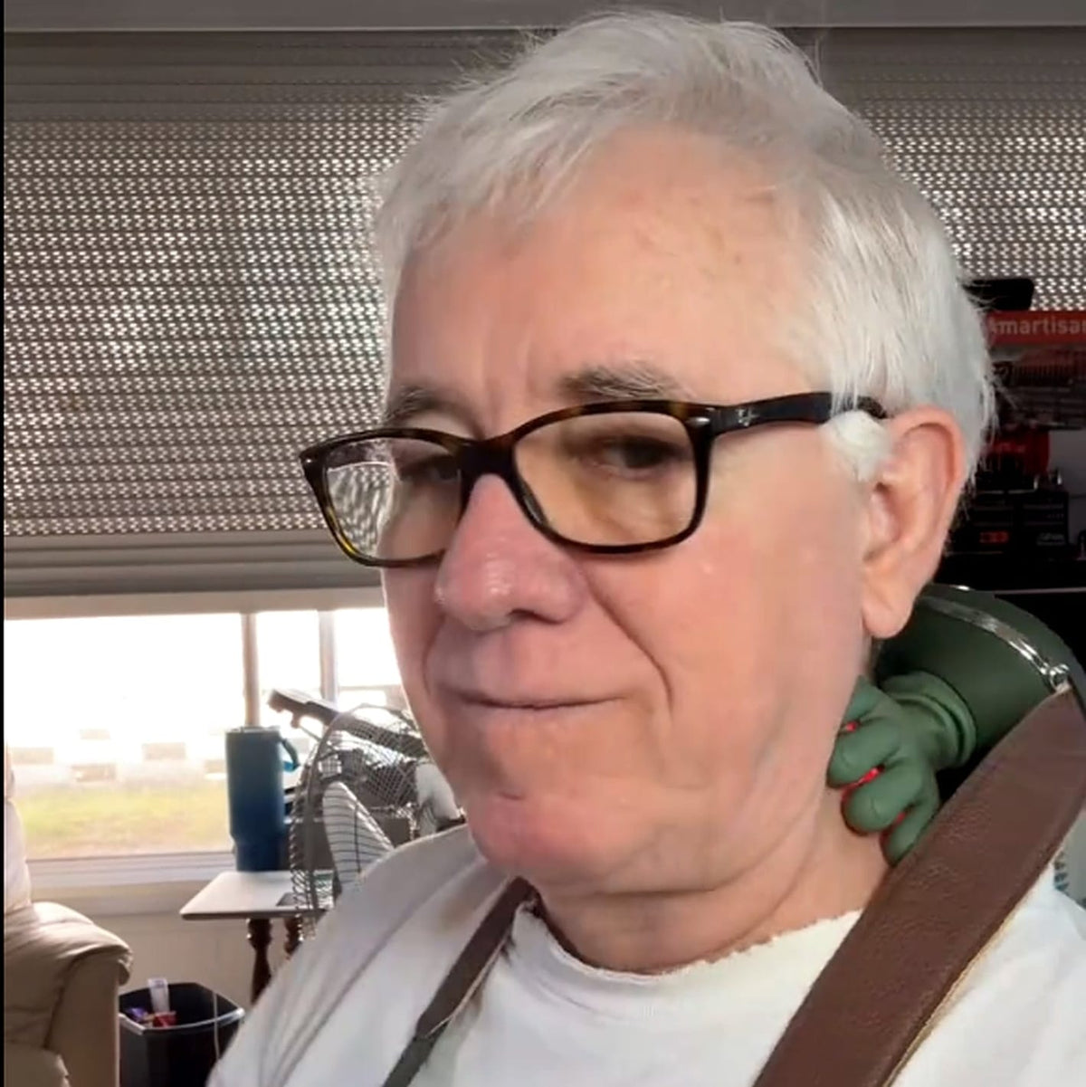 Older woman wearing the green hands-free massager at the side of her neck