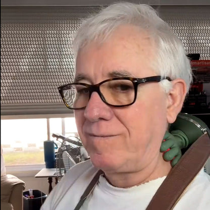 Older woman wearing the green hands-free massager at the side of her neck