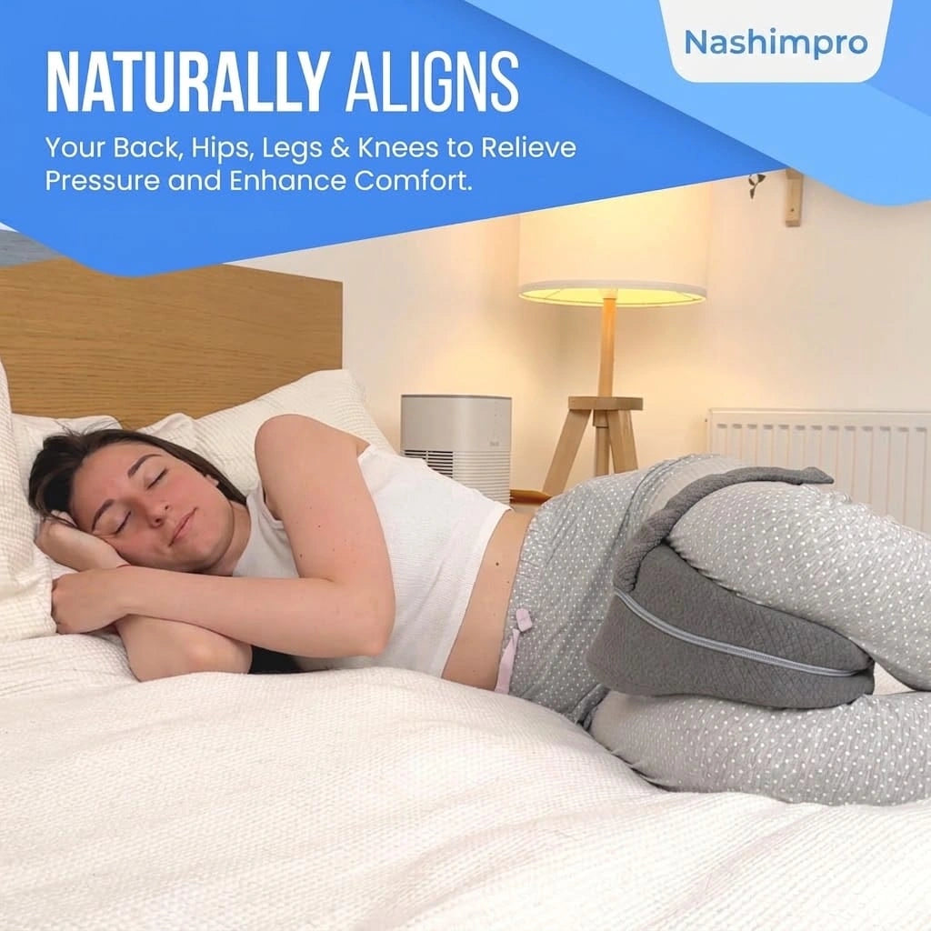 Woman sleeping on her side with a gray alignment pillow secured between her knees